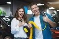 Young family couple handsome man and beautiful brunette woman holding charging cable for electric car , looking excited Royalty Free Stock Photo