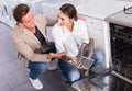 Young family couple looking at dishwashers Royalty Free Stock Photo