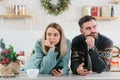 Young family couple quarreled over mobile phone and social networks, man and woman sad during the New Year holidays and Christmas Royalty Free Stock Photo