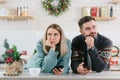 Young family couple quarreled over mobile phone and social networks, man and woman sad during the New Year holidays and Christmas Royalty Free Stock Photo