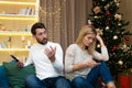 Young family couple quarreled over mobile phone and social networks, man and woman sad during the New Year holidays and Royalty Free Stock Photo