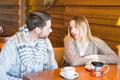 Young family couple with serious faces quarrelling in cafe