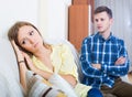 family couple with serious faces quarrelling at home