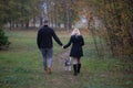 Rear view on young family couple with siberian husky dog walking in autumn park Royalty Free Stock Photo