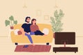 Young family couple sitting on sofa and watching TV movie in living room. Home leisure spare time, people resting and Royalty Free Stock Photo