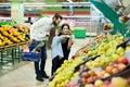 A young family with a daughter choose apples in the vegetable Department in the supermarket Royalty Free Stock Photo