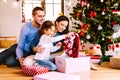 Young family with daughter at Christmas tree at home. Royalty Free Stock Photo