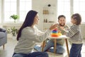 Young family with a daughter playing an educational pyramid game at home together. Royalty Free Stock Photo