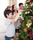 Young family decorating a Christmas tree