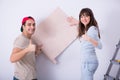 The young family doing renovation at home with new wallpaper Royalty Free Stock Photo