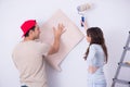 The young family doing renovation at home with new wallpaper Royalty Free Stock Photo