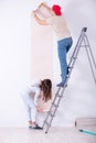 The young family doing renovation at home with new wallpaper Royalty Free Stock Photo