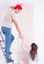 The young family doing renovation at home with new wallpaper Royalty Free Stock Photo