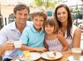 Young Family Enjoying Cup Of Coffee And Cake