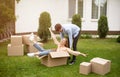 Young family enjoying moving day, being silly together in front yard of their new home