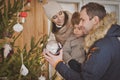 Young family enjoying their holiday time together, decorating Christmas tree outdoors in warm clothes Royalty Free Stock Photo