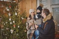 Young family enjoying their holiday time together, decorating Christmas tree outdoors in warm clothes Royalty Free Stock Photo