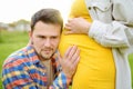 Young family is expecting a baby. Handsome man touching the belly of pregnant woman and feeling the movements of the child Royalty Free Stock Photo