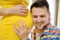 Young family is expecting a baby. Handsome man touching the belly of pregnant woman and feeling the movements of the child Royalty Free Stock Photo