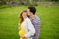 Young family is expecting a baby. Happy couple of parents-to-be walking together. Husband embracing wife gently and holding her Royalty Free Stock Photo