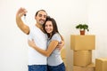 Young family extremely happy because they bought a new house. Man showing keys to the camera. Royalty Free Stock Photo