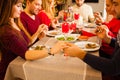 Young family and friends praying and blessing the table at christmas dinning