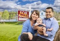 Young Family in Front of Sold Real Estate Sign and House Royalty Free Stock Photo