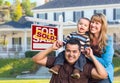 Young Family in Front of Sold Real Estate Sign and House Royalty Free Stock Photo