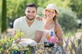 Young family in gloves in plants garden Royalty Free Stock Photo