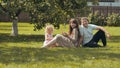 A young family on the grass in the garden outside their home. Royalty Free Stock Photo