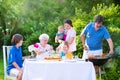 Young family grilling meat for lunch with grandmother Royalty Free Stock Photo
