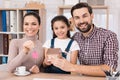 Young family is happy to buy new house, holding keys from house and miniature house. Royalty Free Stock Photo