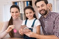 Young family is happy to buy new house, holding keys from house and miniature house. Royalty Free Stock Photo