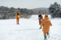 Young family having fun in winter snowy forest Royalty Free Stock Photo