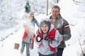 Young Family Having Snowball Fight Royalty Free Stock Photo