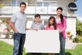 Young family holding a black white board Royalty Free Stock Photo