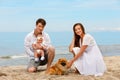 Young family with a infant and Pomeranian dog relax on the beach Royalty Free Stock Photo