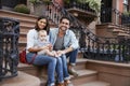 Young family with kids sitting on front stoops