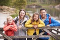 Young family leaning on a wooden fence in the countryside, looking at camera, close up Royalty Free Stock Photo