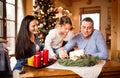 Young family lighting candles on advent wreath. Christmas tree. Royalty Free Stock Photo