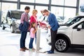 Young family listens carefully car dealers Royalty Free Stock Photo