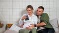 Young family looks at ultrasound picture and strokes belly Royalty Free Stock Photo