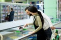 A young family, a man and a woman choose berries in a large supermarket. Royalty Free Stock Photo