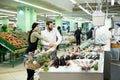 A young family, a man and a woman choose fish in a large supermarket Royalty Free Stock Photo