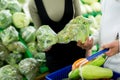 A young family, a man and a woman choose vegetables, cabbage in a large supermarket Royalty Free Stock Photo