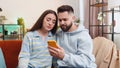 Family couple man woman use smartphone surprised by bad news, fortune loss, fail, lottery results