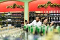 A young family, a man and a woman choose alcohol in a large supermarket Royalty Free Stock Photo