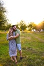 Young family mom dad walking in the evening in a Park with trees in the sunset light. Couple hugging. Happy young couple Royalty Free Stock Photo