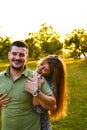 Young family mom dad walking in the evening in a Park with trees in the sunset light. Couple hugging. Happy young couple Royalty Free Stock Photo