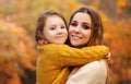 Young family, mother and little son, on walk in autumn forest, mom and child holding hands and walking along path covered with Royalty Free Stock Photo